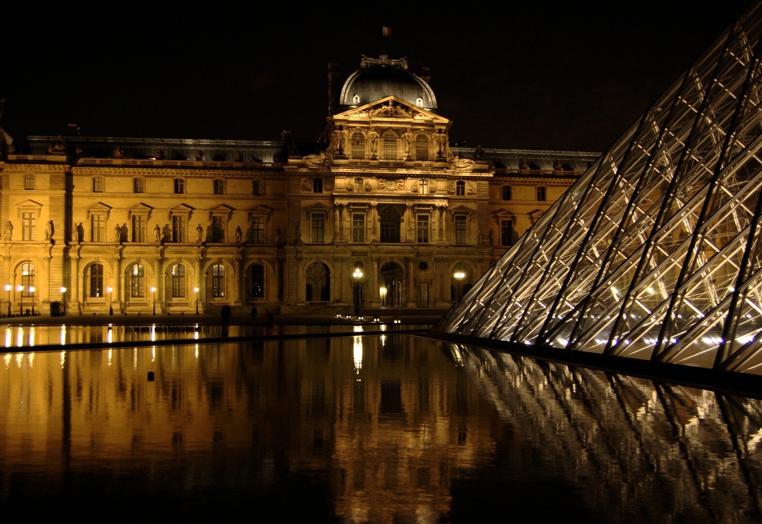 Pirámide de cristal del Museo del Louvre iluminada por la noche en París